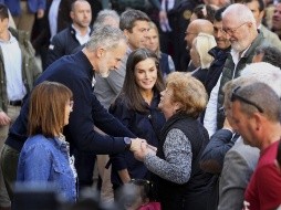 El rey Felipe VI de España habla con una mujer junto a la reina Letizia, mientras visitan la zona devastada por las inundaciones del mes pasado en Chiva, cerca de Valencia, España.